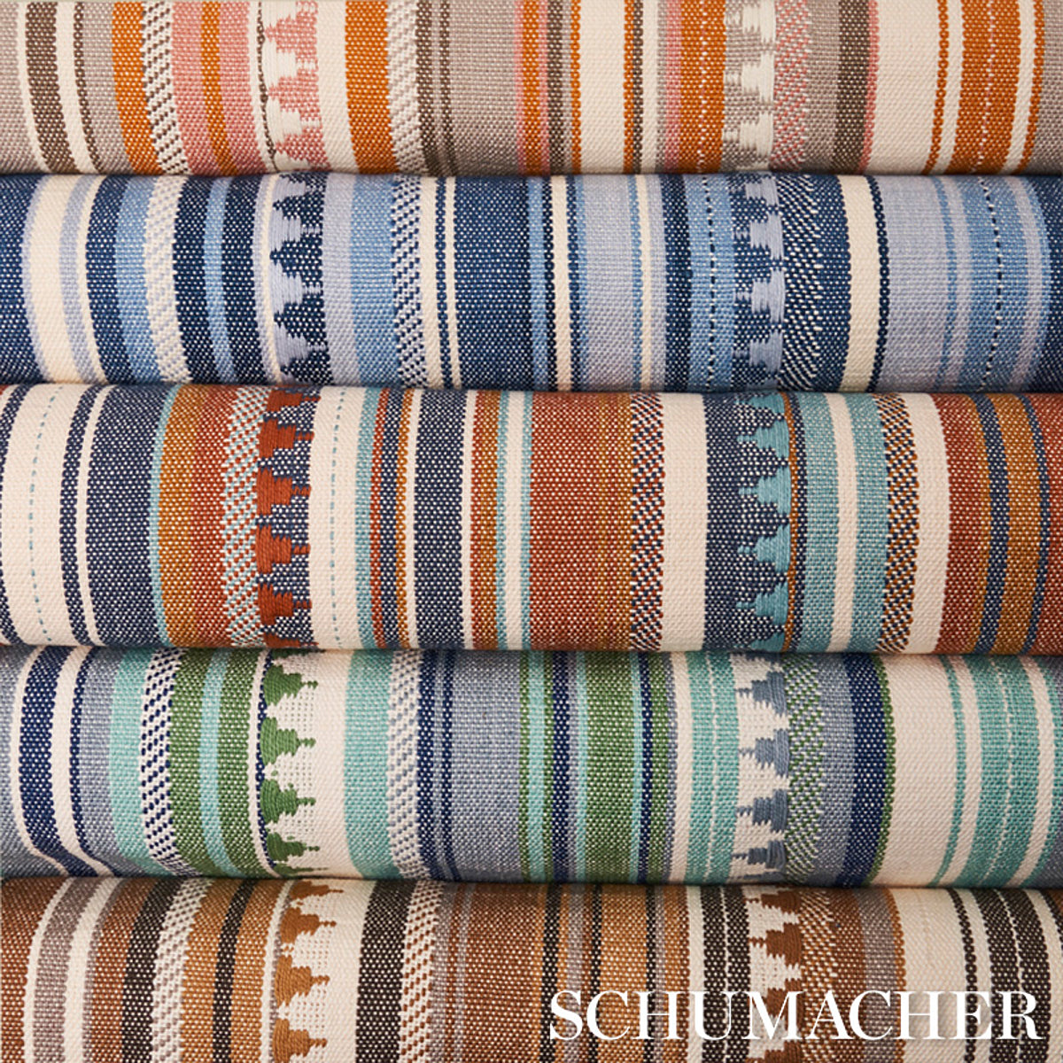 Stacked woven serape-style fabrics in orange, blue, teal and green stripes.