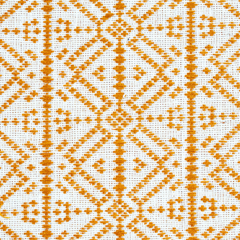 Orange geometric embroidery on white fabric with diamond and line motifs; decorative textile.