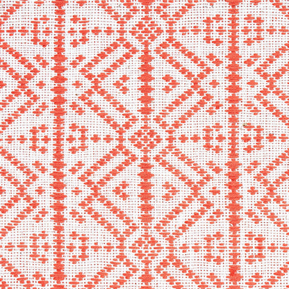 Orange-red geometric lattice embroidery on white fabric; diamond motifs with cross accents in a traditional textile pattern.