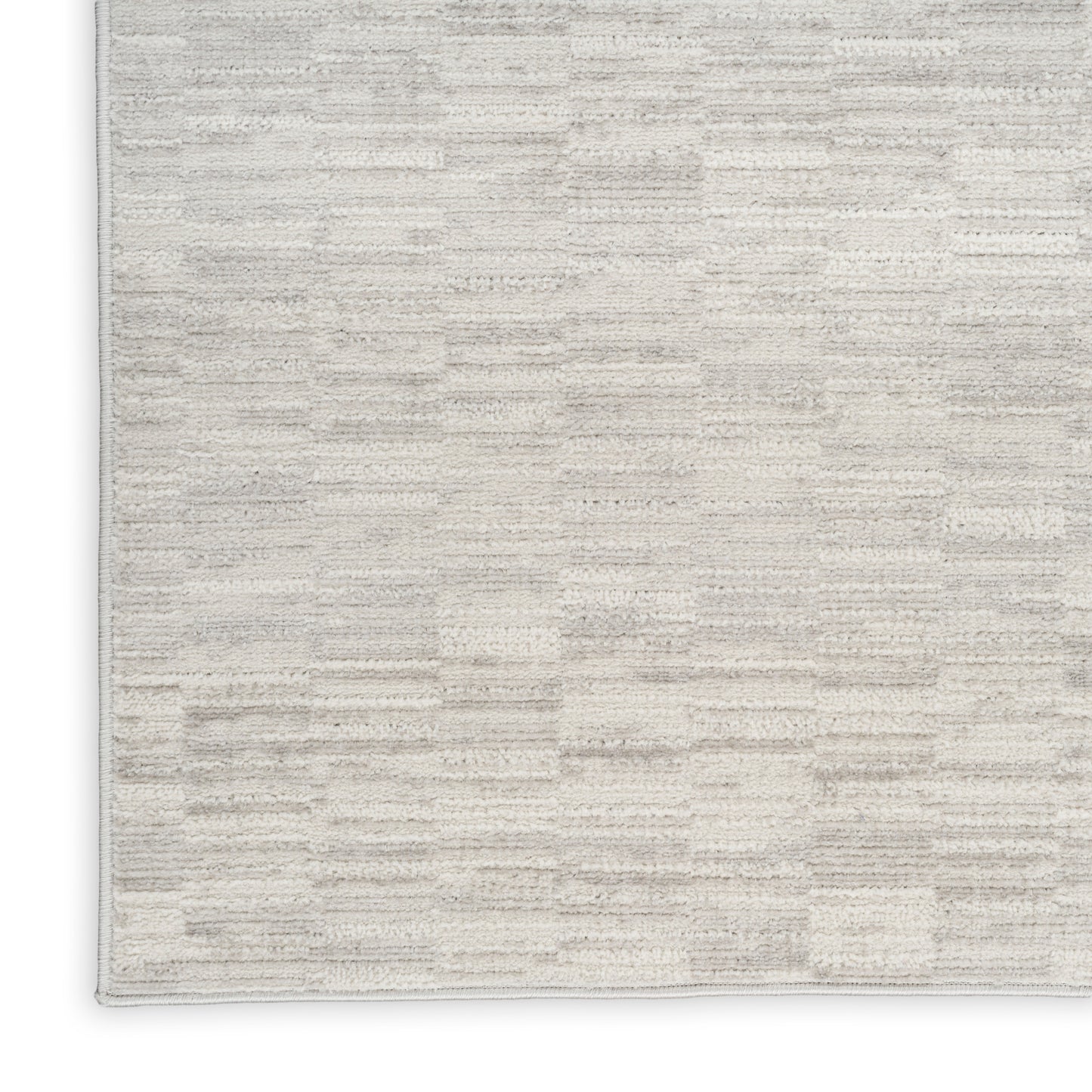 Beige rectangular area rug with a subtle cream geometric block pattern and soft plush texture.