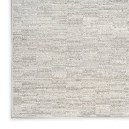 Beige rectangular area rug with a subtle cream geometric block pattern and soft plush texture.