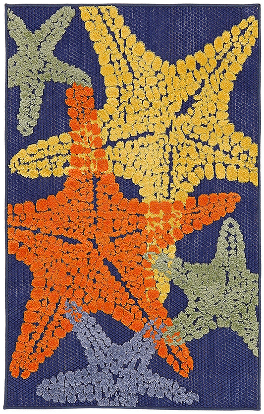 Navy tufted rug with large textured starfish motifs in orange, yellow, sage green, lavender and blue.