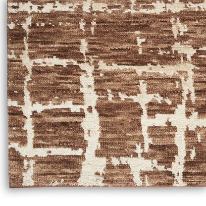 Brown plush rug with cream abstract geometric grid pattern.