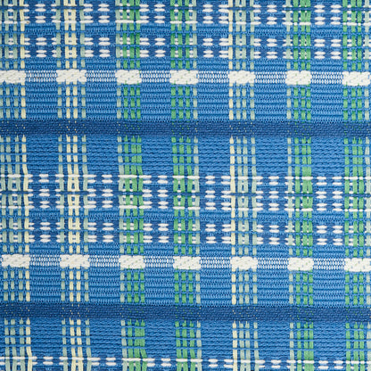 Close-up of blue woven fabric with white and green plaid checks, textured interlaced threads.