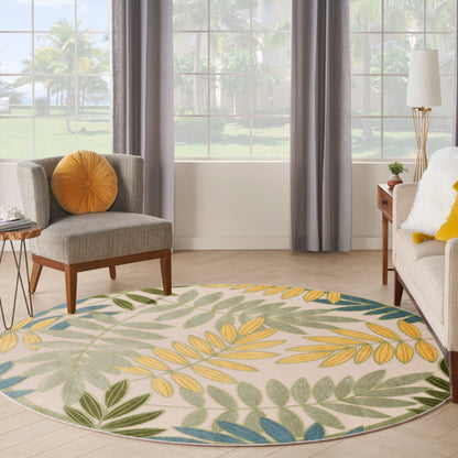 Round botanical outdoor rug with yellow, green and blue leaves on cream.