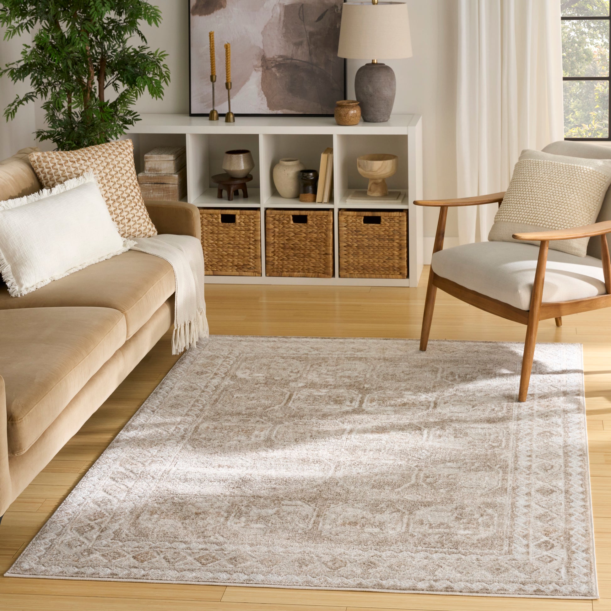 Neutral living room with beige sofa, mid-century wooden chair, white cubby storage with woven baskets, and a light-gray rug.