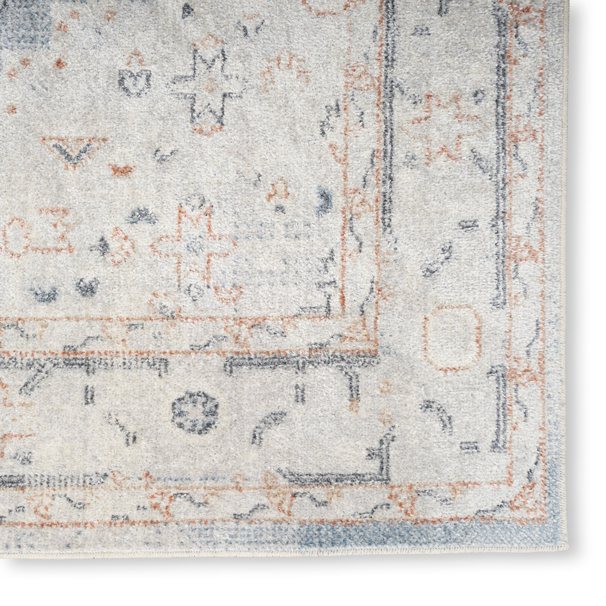 Cream and pale blue oriental area rug with rust accents and decorative border; soft plush pile.