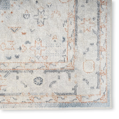 Cream and pale blue oriental area rug with rust accents and decorative border; soft plush pile.