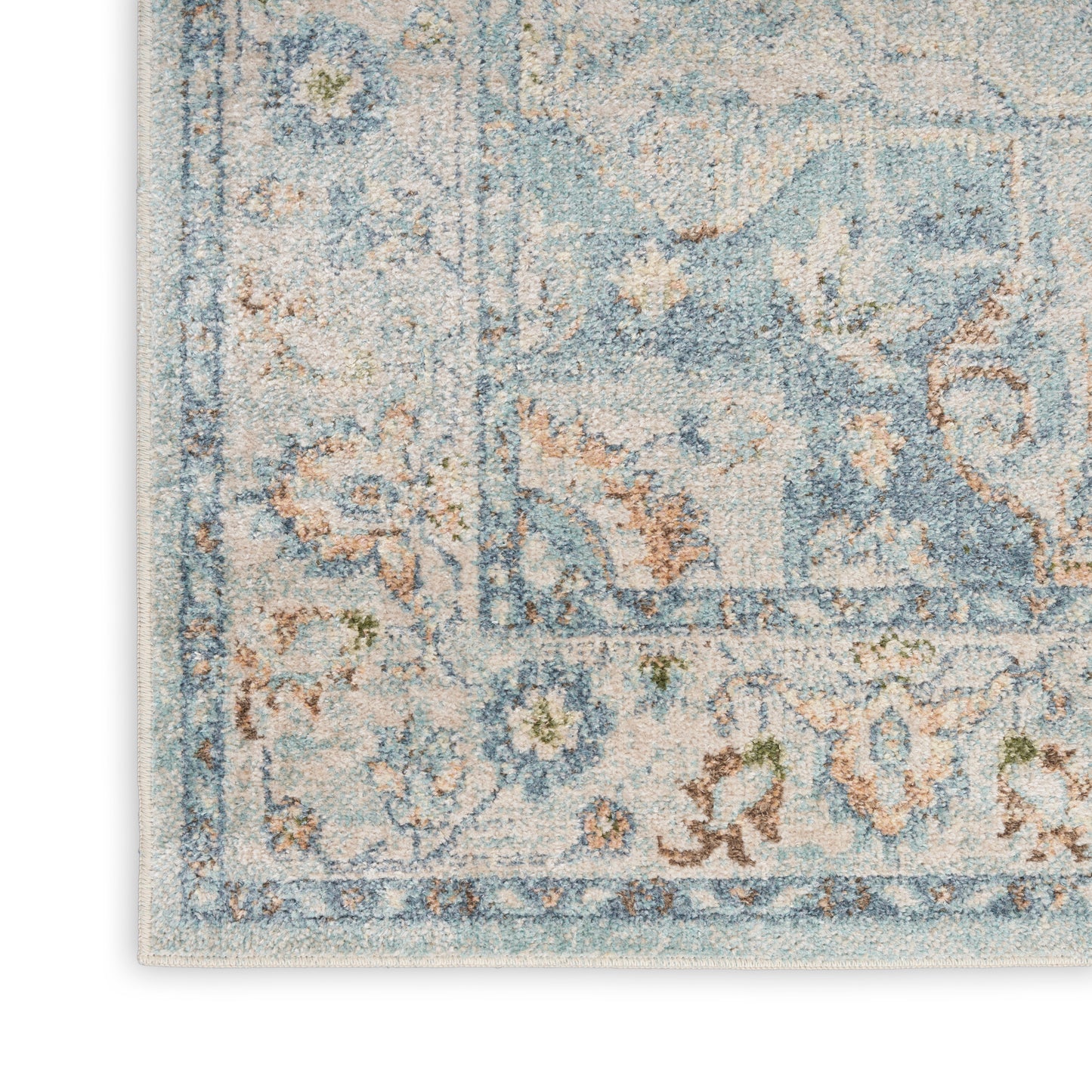 Pastel blue and ivory oriental rug with floral motifs, decorative border and visible fringe.