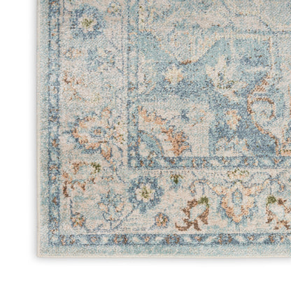 Pastel blue and ivory oriental rug with floral motifs, decorative border and visible fringe.