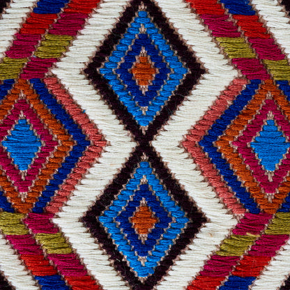 Kilim-style woven rug with diamond geometric motifs in blue, orange, pink, white and black.