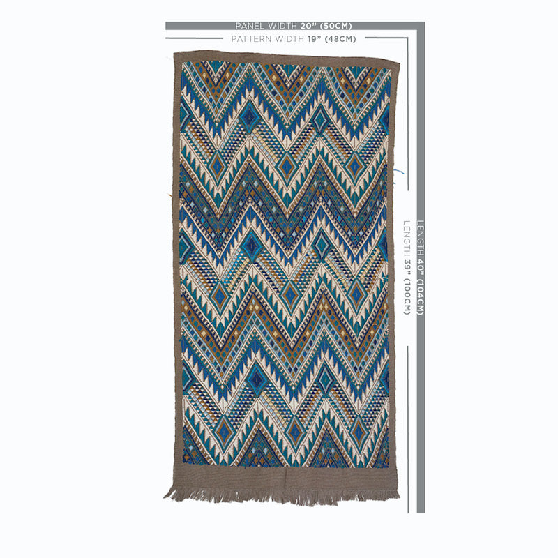 Rectangular woven rug with blue, teal, brown chevron zigzag pattern and beige fringe along edges.