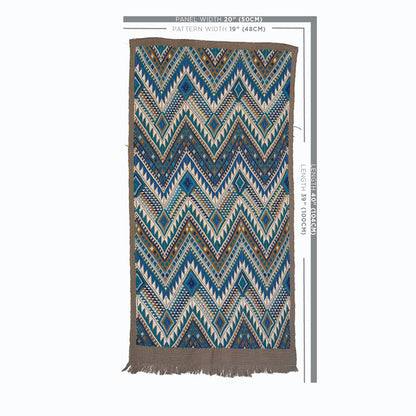 Rectangular woven rug with blue, teal, brown chevron zigzag pattern and beige fringe along edges.
