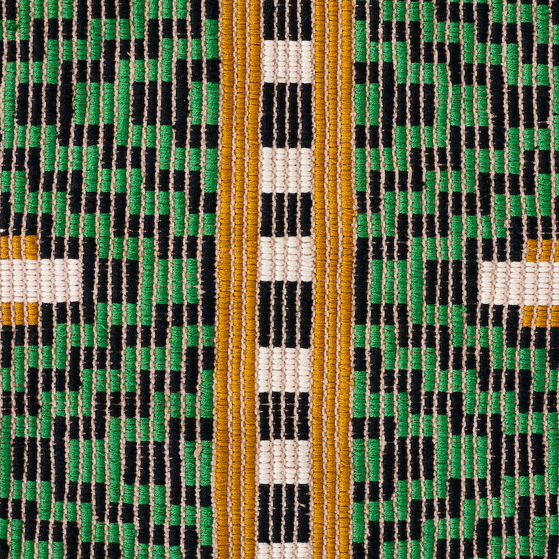 Close-up of hand-woven brocade textile with green, black and white geometric pattern and gold-orange vertical stripes.