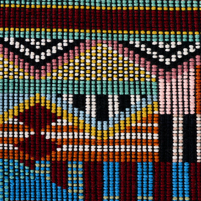 Close-up of multicolor hand-woven brocade textile with a zigzag geometric pattern in turquoise, red, yellow, white, and black.