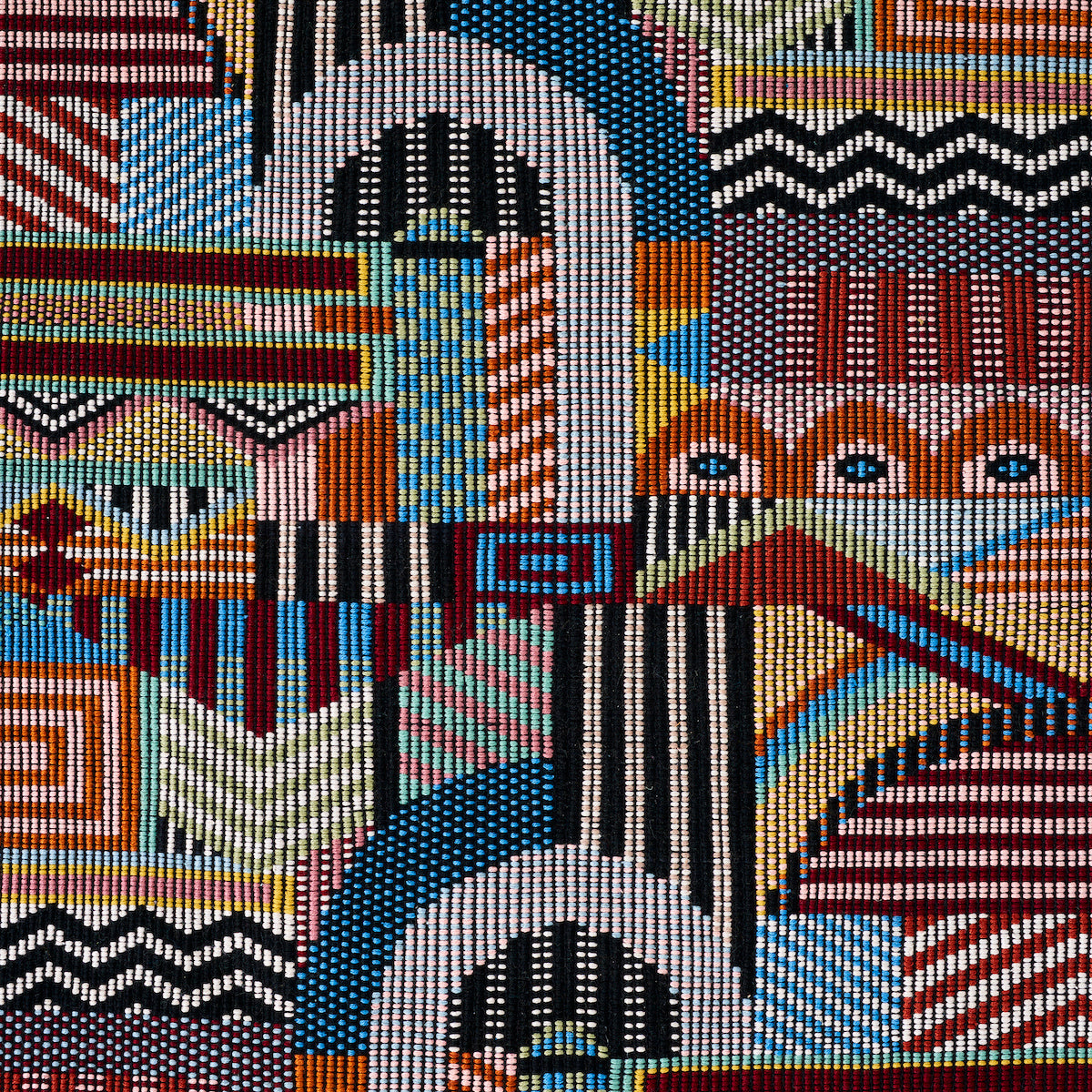 Hand woven brocade-pattern textile with colorful patchwork of geometric blocks, zigzags, stripes and dots in red, blue, black, white and yellow.