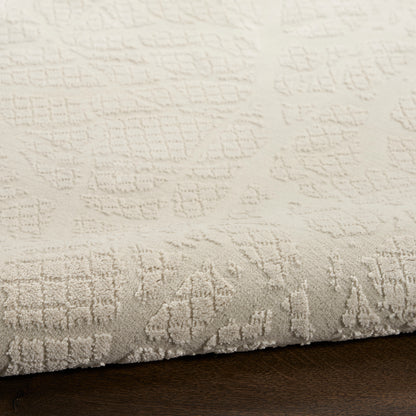 Cream textured area rug with subtle raised geometric pattern, plush pile on dark wood floor.