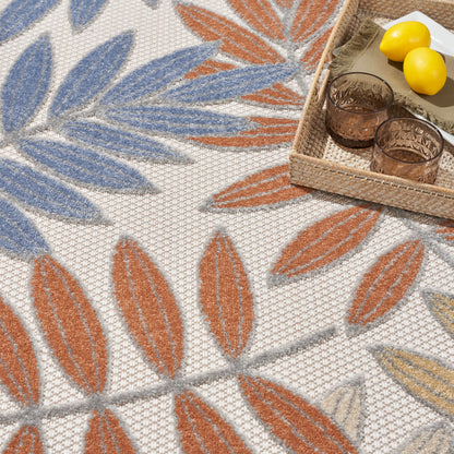 Outdoor woven rug with blue and orange leaf motifs on beige