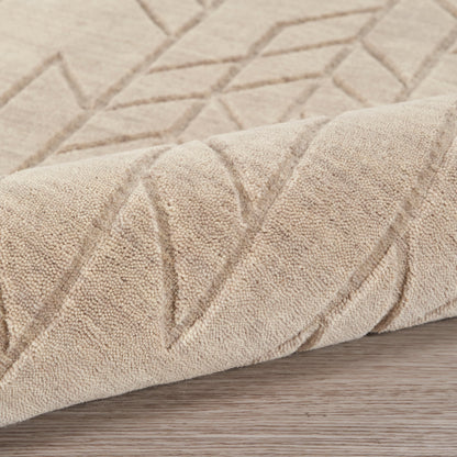 Beige textured rug with geometric diamond pattern, rolled at edge on wooden floor.
