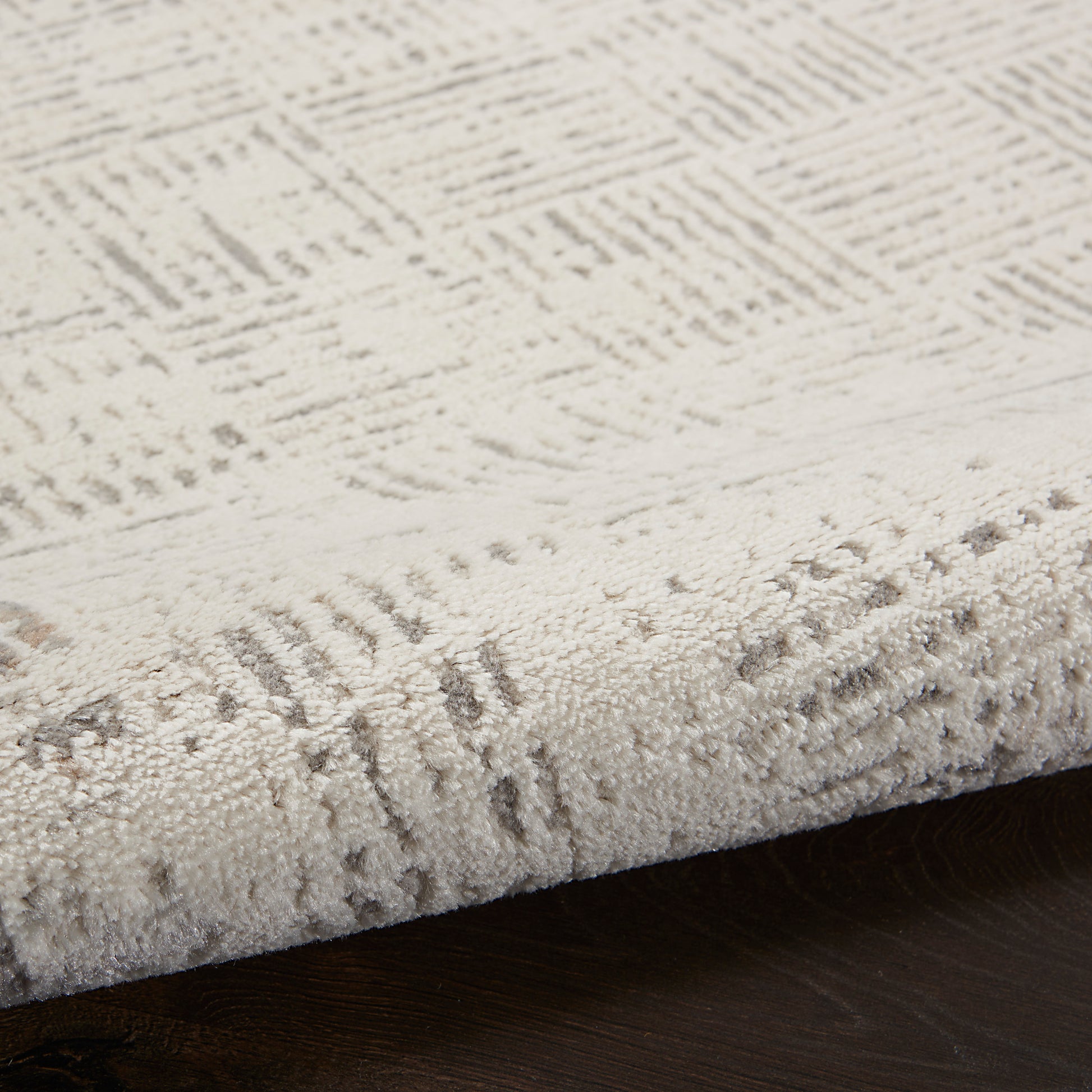 Beige textured runner rug with subtle geometric pattern, low-pile, on dark wood floor.
