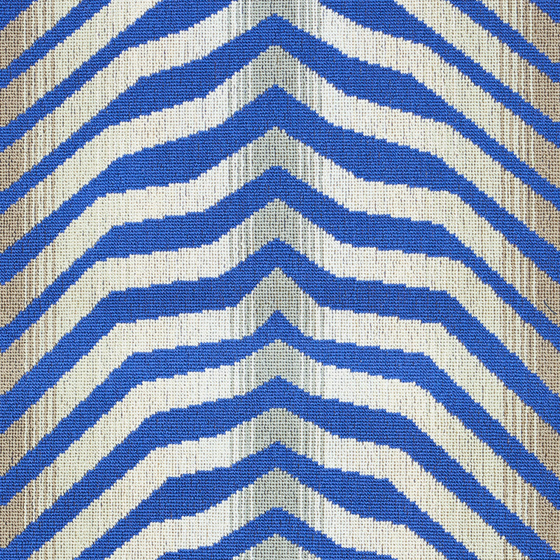 Blue and white chevron striped woven rug with beige edging; bold geometric textile.