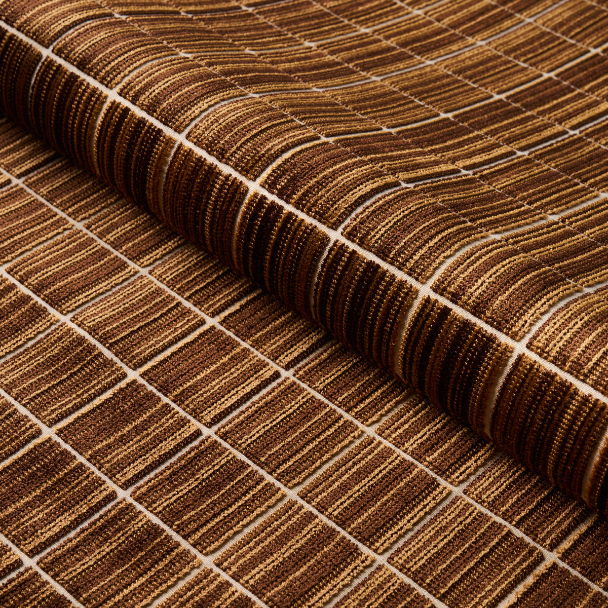 Rolled brown woven seagrass rug with white grid stripes; rustic natural floor mat.