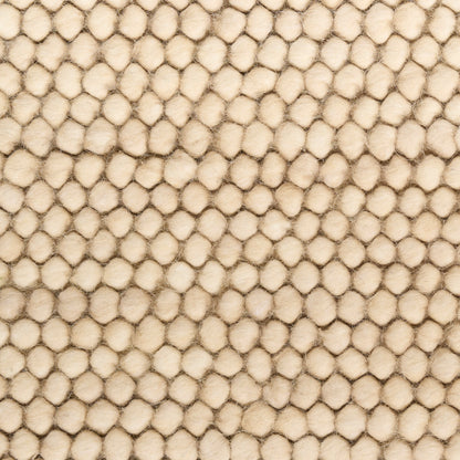 Beige bubble-textured fabric with evenly spaced rounded tufts; soft upholstery or rug material.
