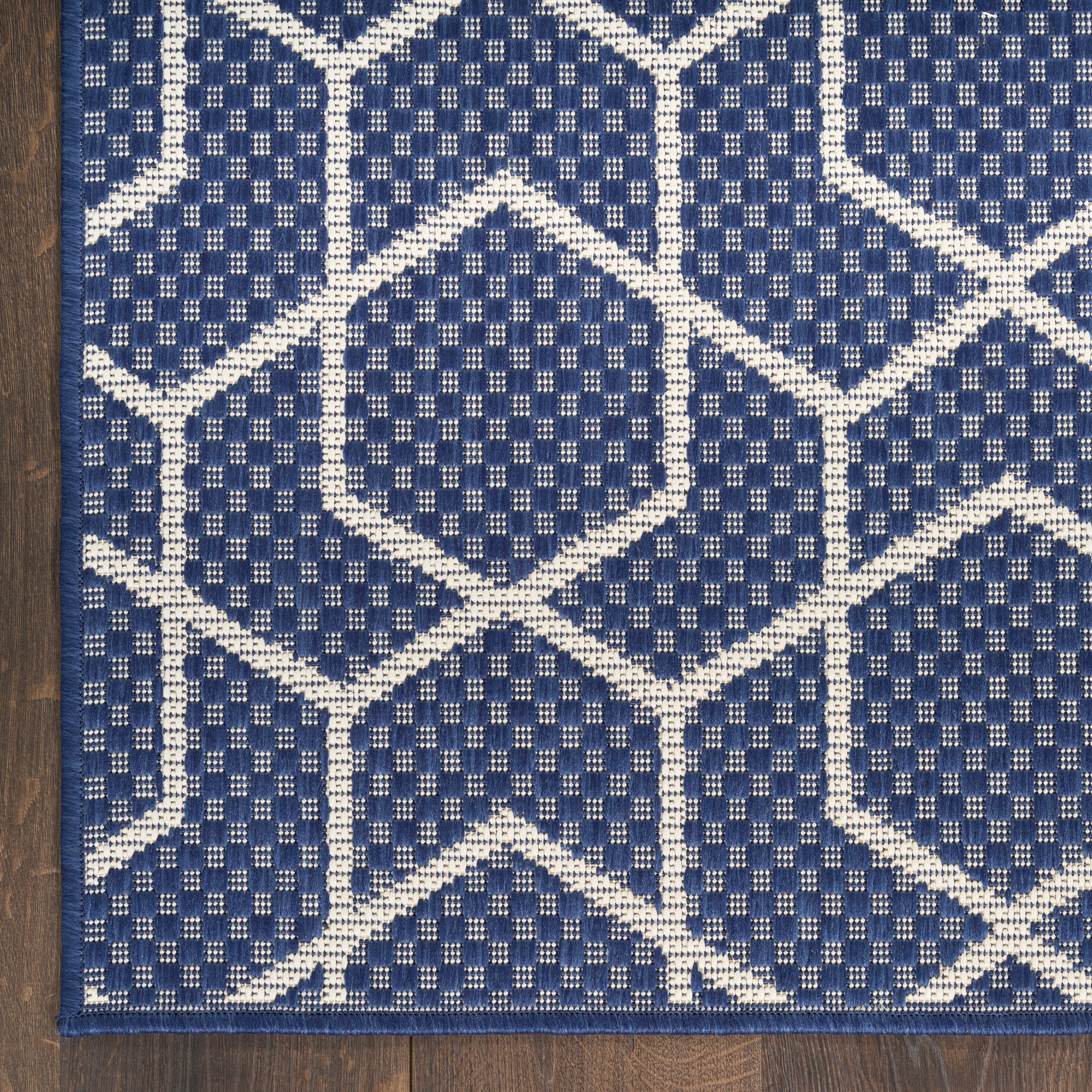 Navy blue rectangular rug with white geometric hexagon and diamond lattice pattern; woven, modern home decor.
