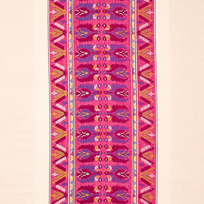 Vibrant magenta woven table runner with repeating central motif and geometric yellow-blue borders.