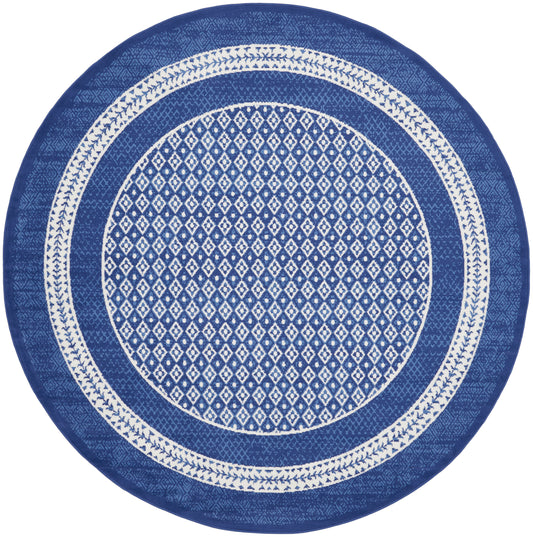 Round blue rug featuring a white diamond lattice center and decorative white border bands.