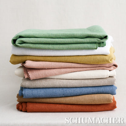 Stack of folded knit fabrics in green, cream, mustard, pink, beige, blue, brown and orange; cozy textile yardage.