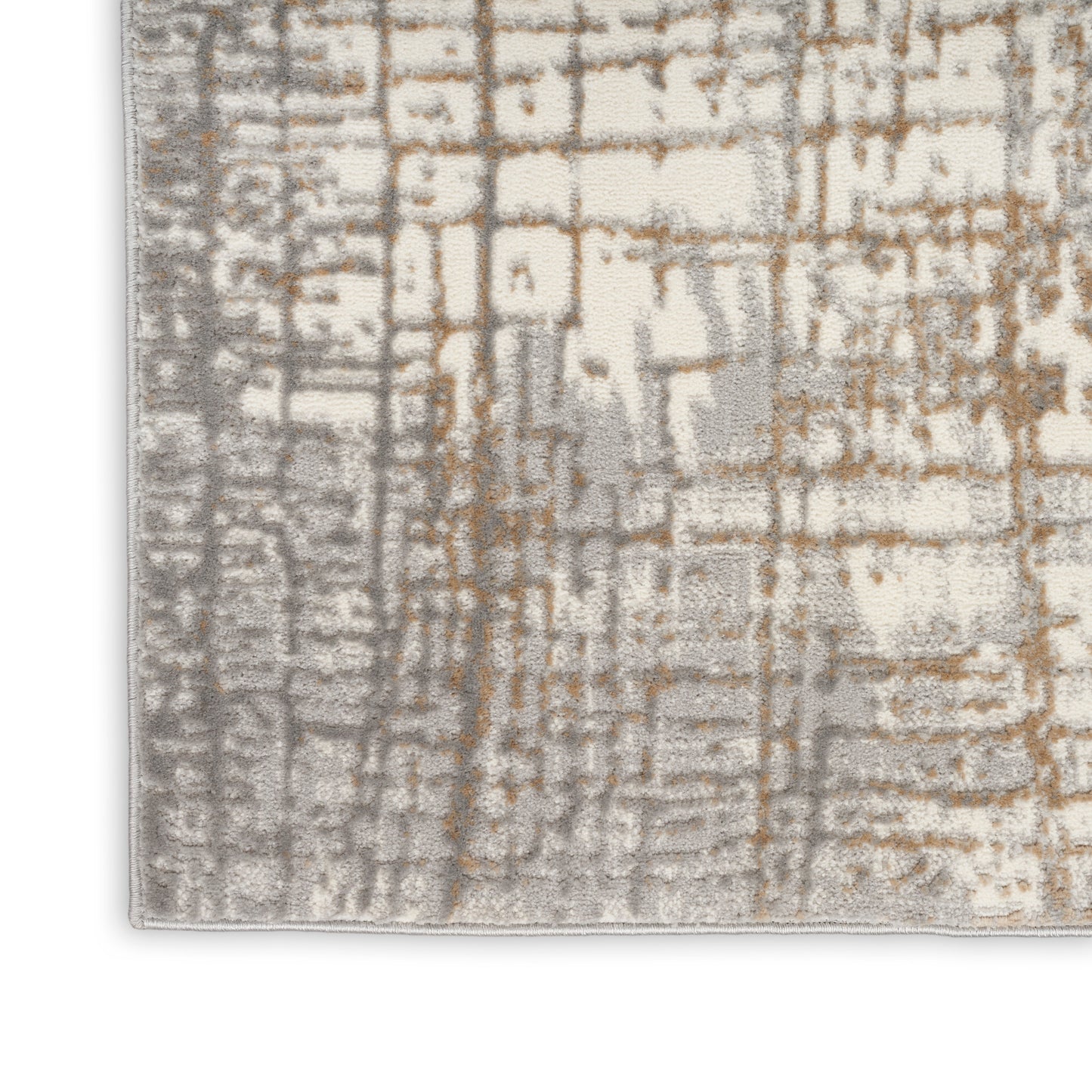 Corner of a textured area rug with a beige base and gray-brown grid-like pattern.