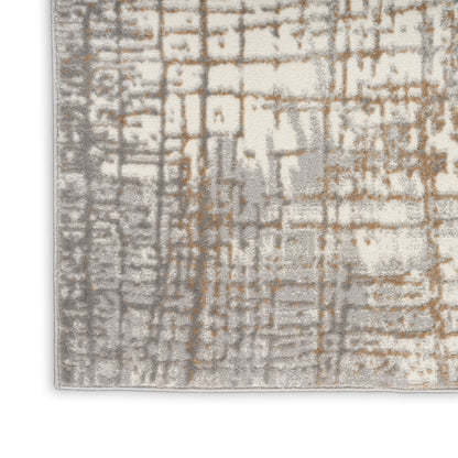 Corner of a textured area rug with a beige base and gray-brown grid-like pattern.