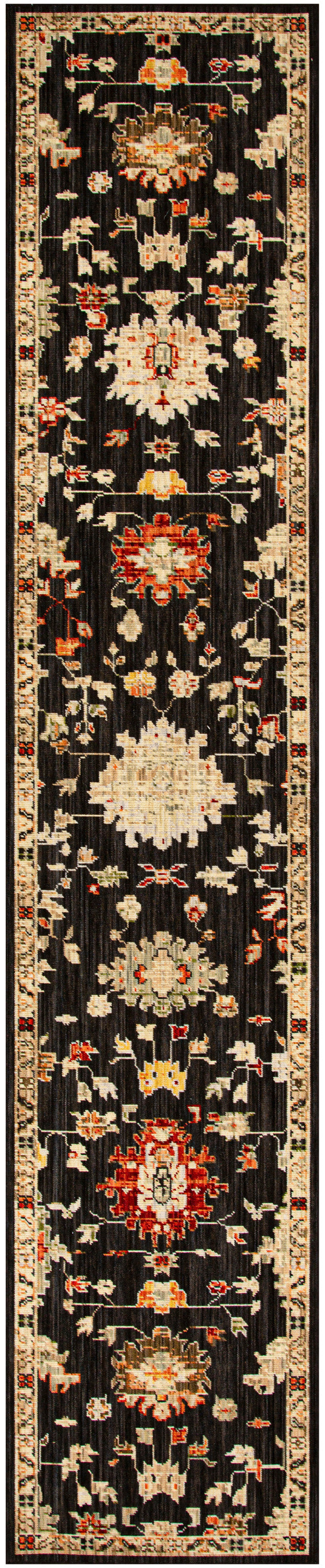Narrow oriental runner rug with black field and cream, red, and gold floral medallions along a bordered edge.
