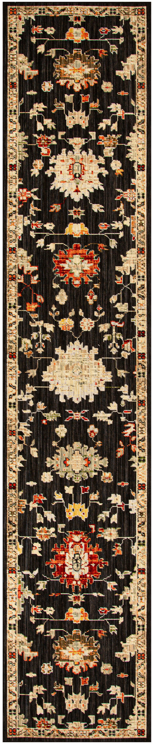 Narrow oriental runner rug with black field and cream, red, and gold floral medallions along a bordered edge.