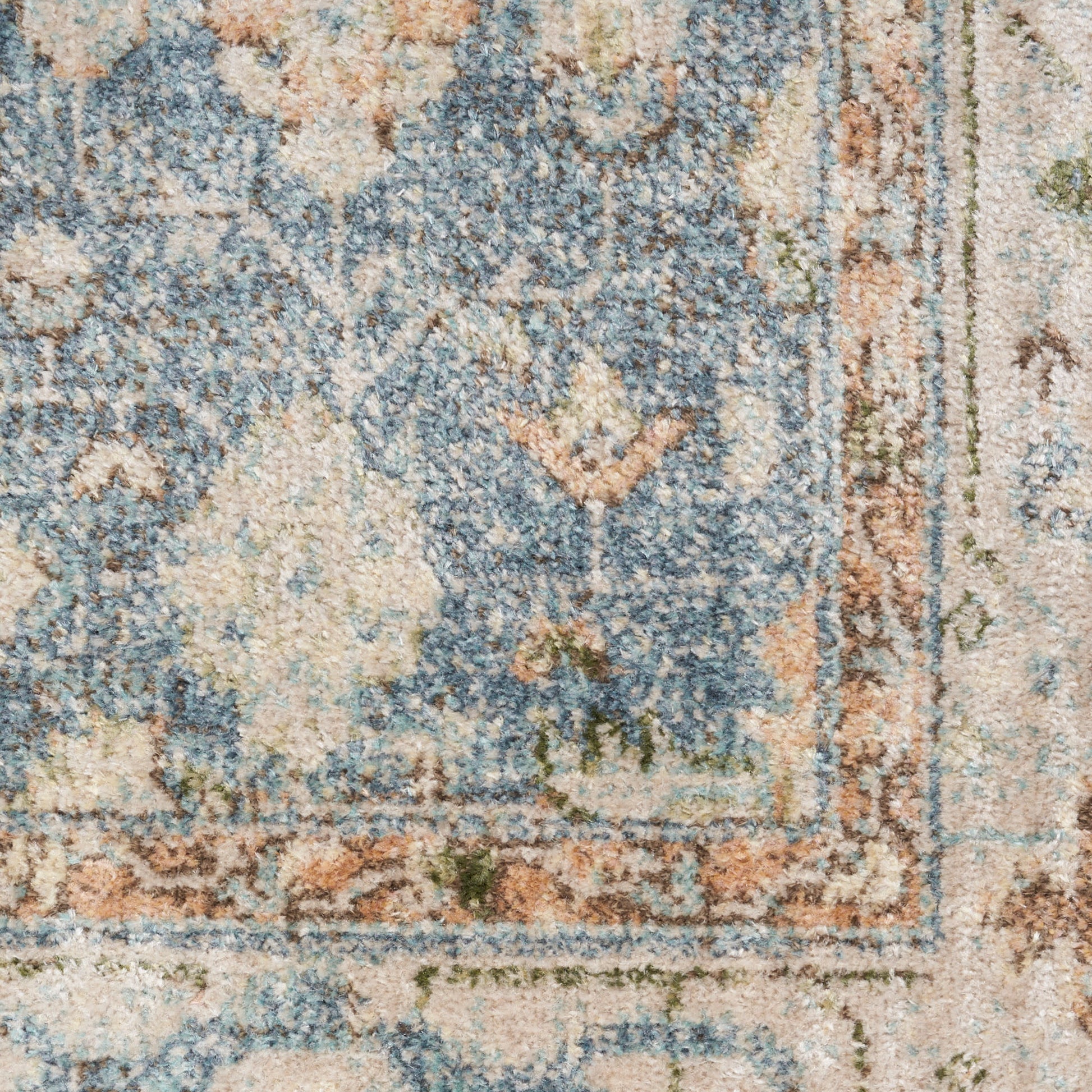 Blue and beige oriental rug close-up with floral motifs and subtle orange accents.