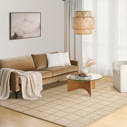 Beige grid rug under a round glass coffee table, with a beige sofa, white pillow and knit throw, and a woven pendant light.