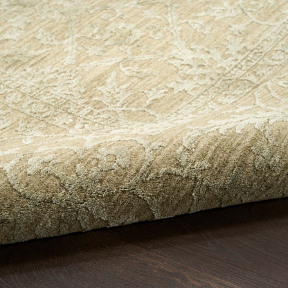 Beige plush patterned rug with raised floral design, edge visible on dark wood floor