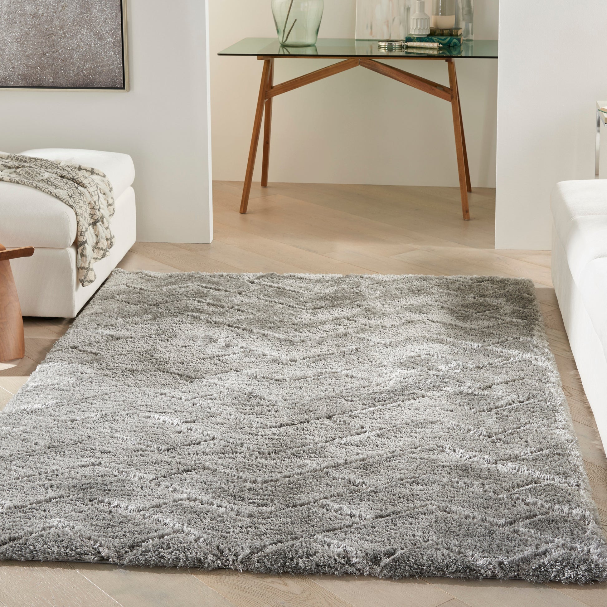 Gray shag area rug with soft, wavy texture on light wood floor in a modern living room.