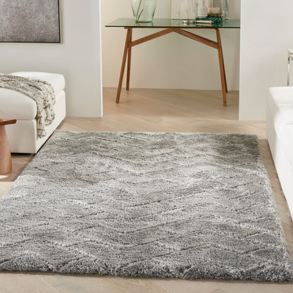 Gray shag area rug with soft, wavy texture on light wood floor in a modern living room.