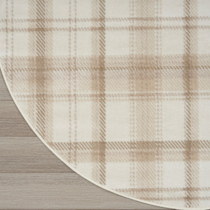 Beige plaid round rug with white binding edge on light wood floor.