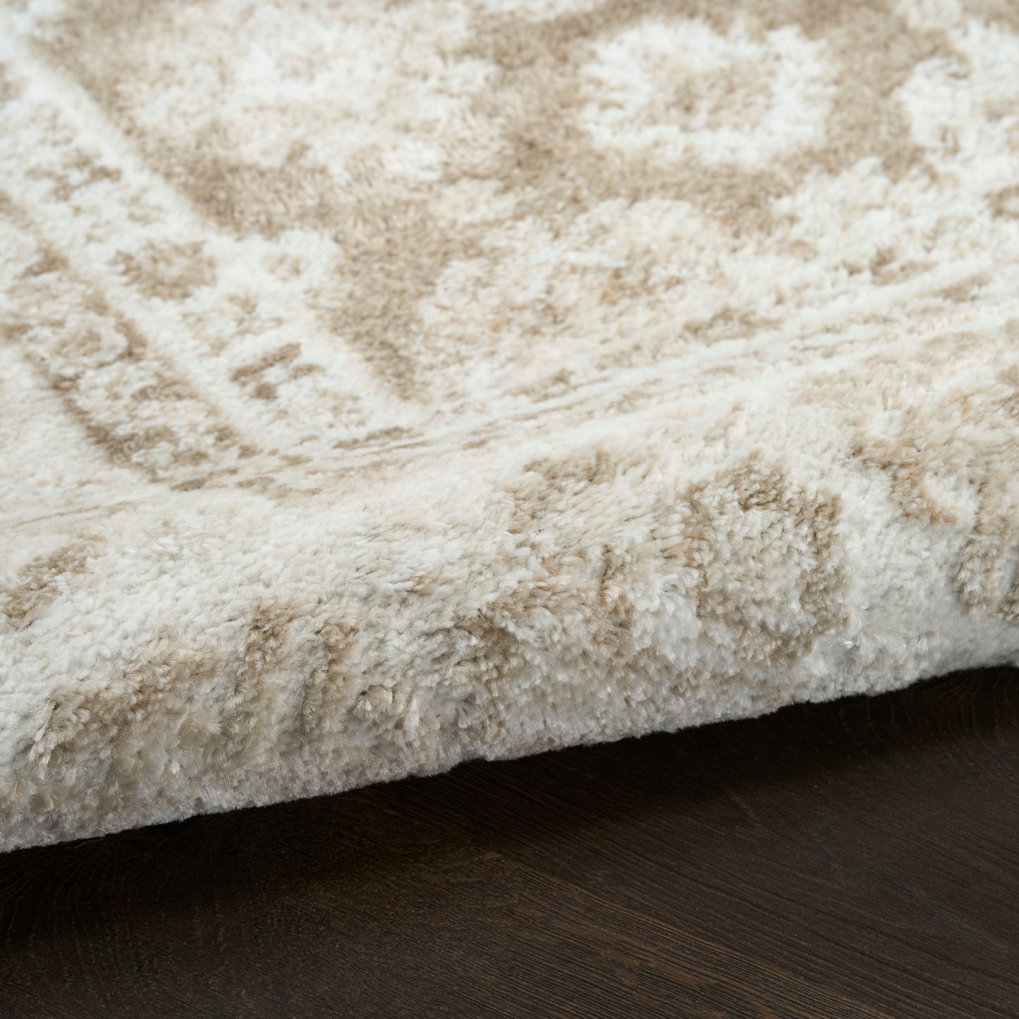 Cream shag rug with plush pile & subtle geometric pattern; soft, cozy floor decor.