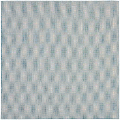 Light gray-blue rug with a tiny blue dot pattern and a stitched border.