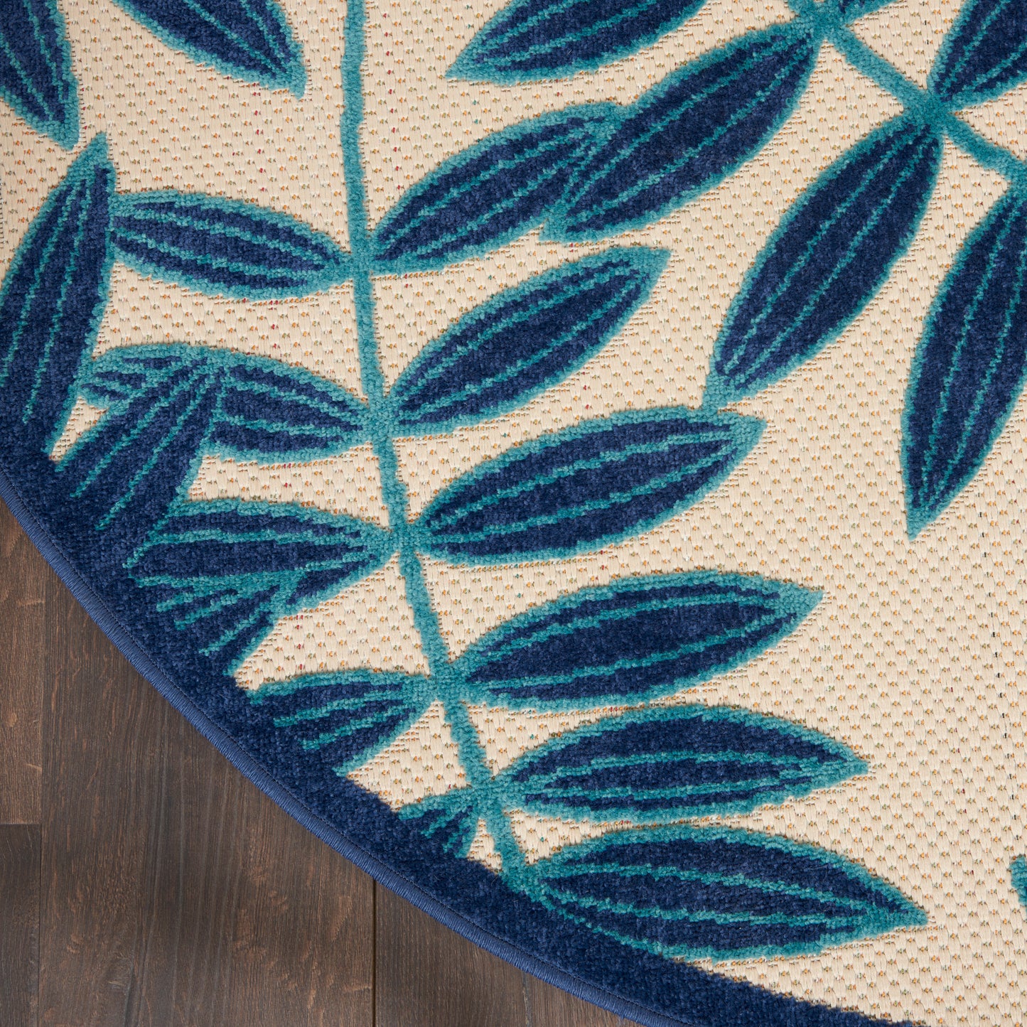Blue leafy-pattern rug on a wood floor.