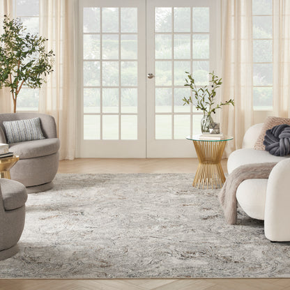 Bright contemporary living room with French doors, beige drapes, gray rounded chairs, white sofa, textured rug, gold metal side table with plant.