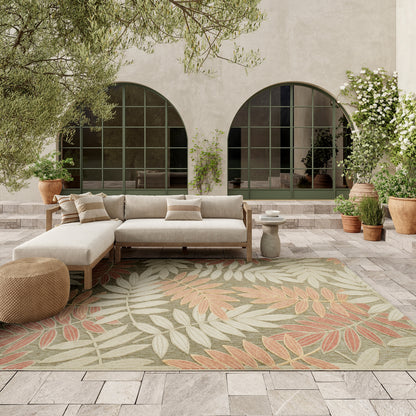 Outdoor patio with beige fabric sectional on a wooden frame, palm-leaf rug, woven pouf, terracotta pots & arched windows.
