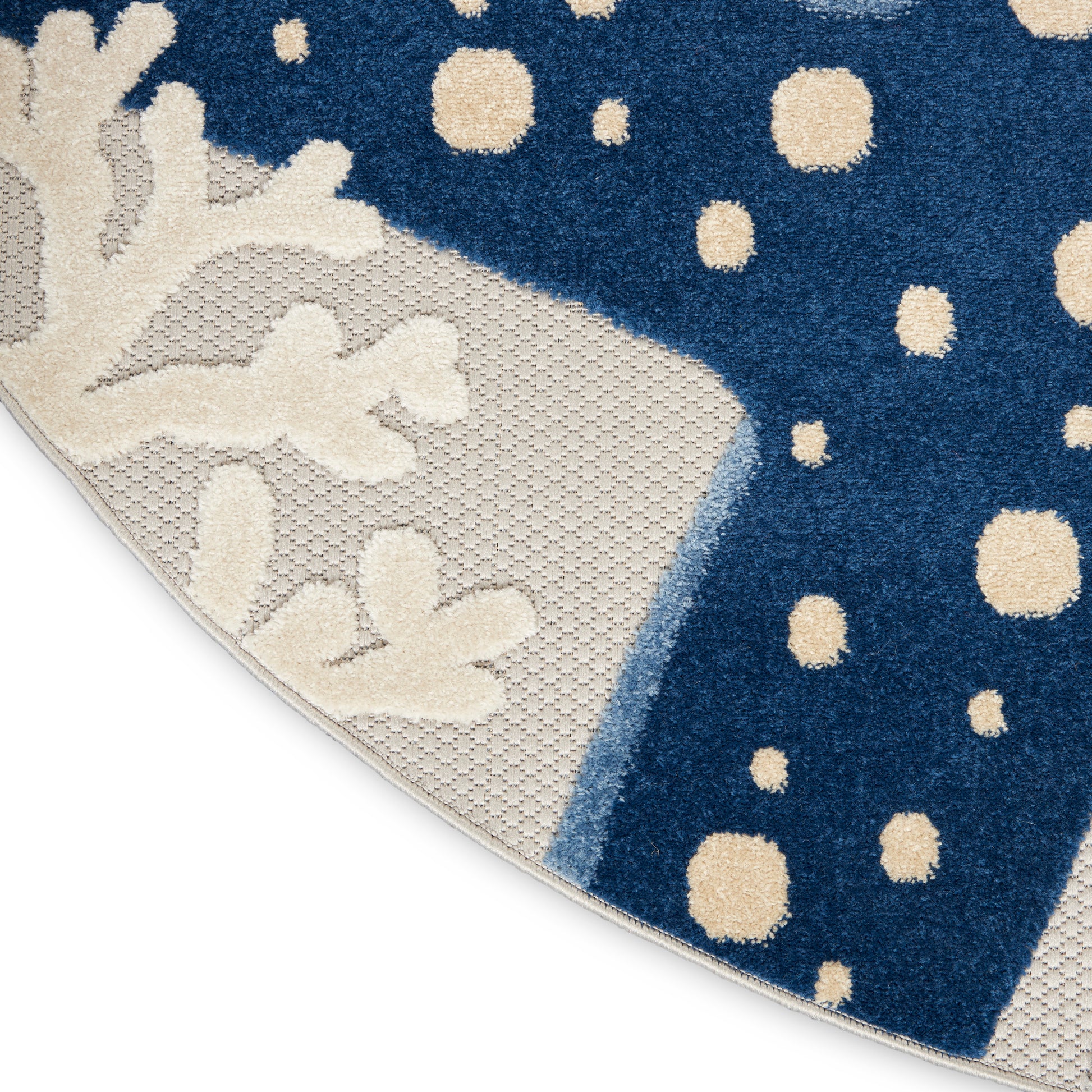 Blue coastal rug with cream coral motif and beige dots, beige textured border, curved corner.
