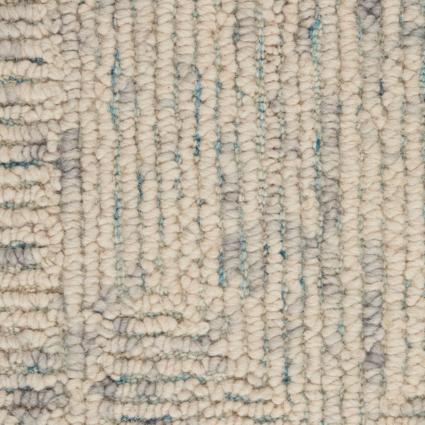 Beige tufted rug close-up with chunky loop pile and pale blue vertical accents; soft, woven wool look.