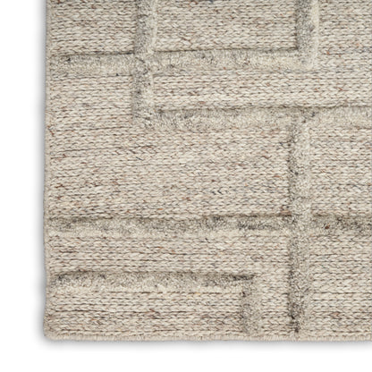 Natural beige jute rug with rectangular geometric grid, textured chunky loop pile in neutral tan tones.