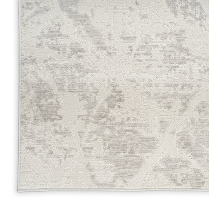 Rectangular beige and gray abstract distressed-pattern rug with soft, plush pile.
